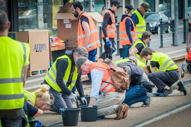 Freiwillige Helfer reinigen gemeinsam mit Mitarbeitenden der Leipziger Verkehrsbetriebe (LVB) Straßenbahngleise an der Leibnizstraße in Leipzig (Sachsen) von geschmolzenem Bitumen. Die Arbeiten sind Teil eines dritten Subbotniks zur Beseitigung der Hitzeschäden am Straßenbahnnetz. Aufnahme vom 4. Juli 2026. Hilfsaktion Leipzig *** Volunteers are working alongside employees of the Leipzig Public Transportation Authority (LVB) to clean melted bitumen from the tram tracks on Leibnizstraße in Leipzig, Saxony. The work is part of a third subbotnik aimed at repairing heat damage to the tram network. Photo taken on July 4, 2026. VolunteerLeipzig Relief Effort