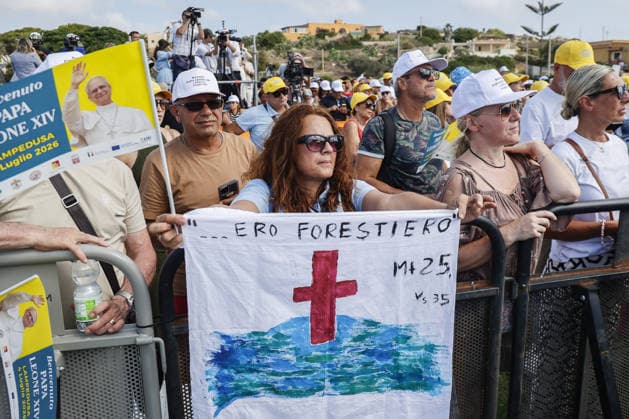 Pope Leo XIV visits the Southern Italian island of Lampedusa LAMPEDUSA, ITALY, JULY 04: A faithful holds a banner reading the quote from the Gospel of Matthew ÒI was foreignerÓ as she waits for the arrival of Pope Leo XIV to celebrate a mass in the sports field on the occasion of his visit to Lampedusa, Italy, on July 04, 2026. Riccardo De Luca Anadolu Lampedusa Italy. Editorial use only. Please get in touch for any other usage.  Copyright: x2026xAnadoluxRiccardoxDexLucax