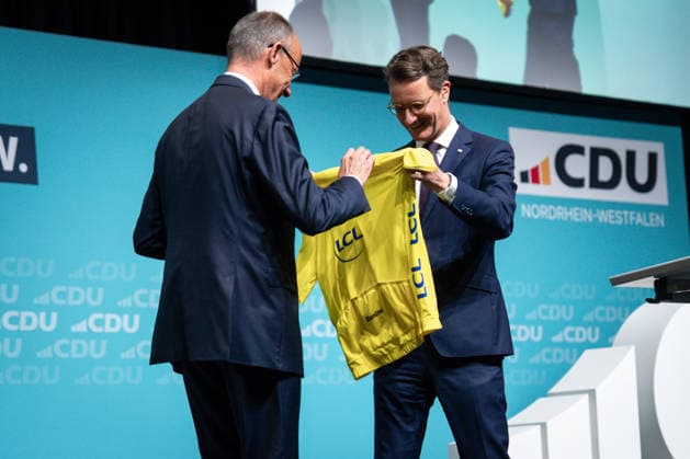 CDU Landesparteitag des Landes Nordrhein-Westfalen in Duesseldorf Hendrik Wuest, Ministerpraesident des Landes Nordrhein-Westfalen ueberreicht Bundeskanzler Friedrich Merz das Gelbe Trikot als Anspielung auf den heutigen Start der Tour de France auf dem CDU Landesparteitag des Landes Nordrhein-Westfalen im Maritim Hotel in NRW, Duesseldorf, 04.07.2026 Duesseldorf Nordrhein-Westfalen Deutschland *** CDU State Party Convention of North Rhine-Westphalia in Düsseldorf Hendrik Wuest, Minister President of North Rhine-Westphalia, presents Chancellor Friedrich Merz with the yellow jersey as a nod to today’s start of the Tour de France at the CDU State Party Convention of North Rhine-Westphalia at the Maritim Hotel in Düsseldorf, July 4, 2026, Dü