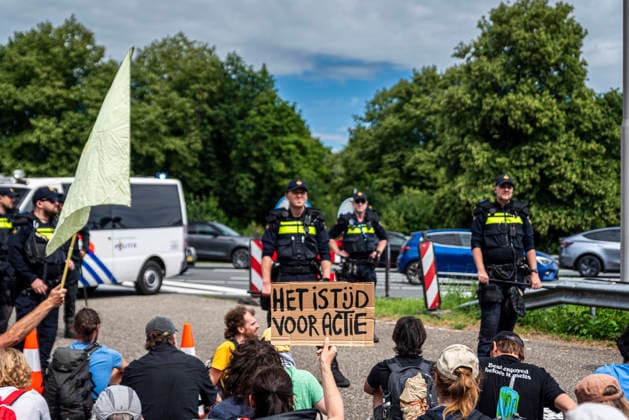 July 4, 2026, Utrecht, Utrecht, Netherlands: 4 July 2026, Utrecht, the Netherlands. A climate activist holds a sign reading It Is Time For Action (translated from Dutch). Climate activists from Extinction Rebellion and Utrecht for Palestine block the A12 highway near Utrecht, Netherlands, demanding an end to billions in annual fossil fuel subsidies. Utrecht Netherlands  - ZUMAp202 20260704_zip_p202_005 Copyright: xJamesxPetermeierx