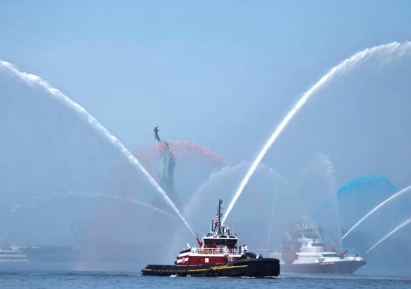 New York City Fire Department boats spray red, white and blue water in the air near he Statue of Liberty as part of Sail4th 250, a celebration for America s 250th anniversary, in New York City on Saturday, July 4, 2026. The event includes over 100 tall ships and navy vessels from more than 30 nations.  NYP20260704228 JOHNxANGELILLO