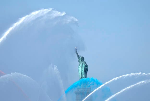 New York City Fire Department boats spray red, white and blue water in the air near he Statue of Liberty as part of Sail4th 250, a celebration for America s 250th anniversary, in New York City on Saturday, July 4, 2026. The event includes over 100 tall ships and navy vessels from more than 30 nations.  NYP20260704233 JOHNxANGELILLO