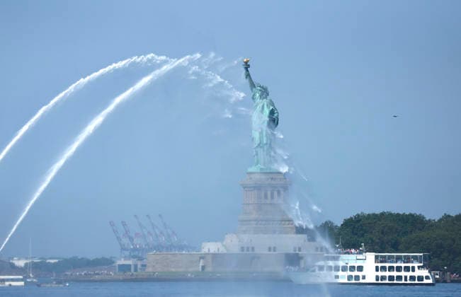 New York City Fire Department boats spray water in the air near the Statue of Liberty as part of Sail4th 250, a celebration for America s 250th anniversary, in New York City on Saturday, July 4, 2026. The event includes over 100 tall ships and navy vessels from more than 30 nations.  NYP20260704235 JOHNxANGELILLO