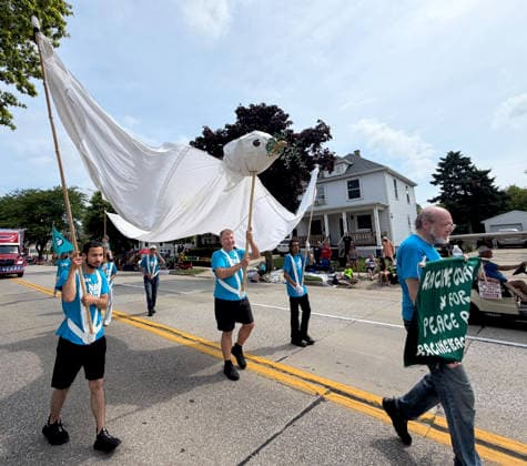 July 4, 2026, Racine, Wisconsin, USA: Holding a large piece dove banner, members of the Racine Coalition for Peace and Justice march as Racine, Wisconsin hosts its 90th annual 4th of July parade on Main Street July 4, 2026.The theme was Ã¢â‚¬oeHappy 250 America. Racine USA  - ZUMAh154 20260704_znp_h154_017 Copyright: xMarkxHertzbergx