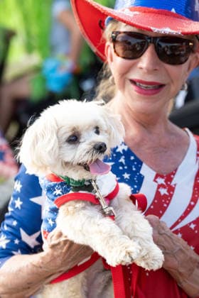 July 4, 2026, Sullivans Island, Sc, United States of America: A woman holds up her dog, Ã¢â‚¬ËœOliverÃ¢â‚¬Â dressed in patriotic costume before the start of the annual Bicycle and Golf cart parade celebrating the 250th Independence Day, July 4, 2026 in Sullivans Island, South Carolina. Like most of the nation, South Carolina is under a heat dome with dangerously hot, humid weather. Sullivans Island United States of America  - ZUMAe02_ 20260704_zaf_e02_008 Copyright: xRichardxEllisx