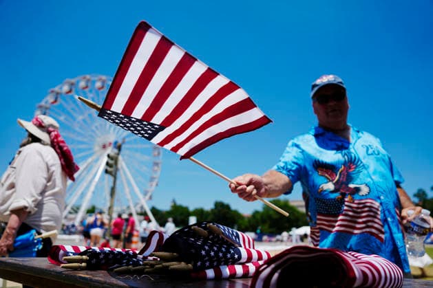 A visitor to the Great American State Fair on the National Mall waves a flags to celebrate America s 250th anniversary in Washington DC on Saturday, July 4, 2026.  WAP20260704503 BONNIExCASH