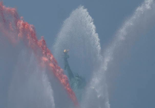 New York City Fire Department boats spray red, white and blue water in the air near the Statue of Liberty as part of Sail4th 250, a celebration for America s 250th anniversary, in New York City on Saturday, July 4, 2026. The event includes over 100 tall ships and navy vessels from more than 30 nations.  NYP202607044012 JOHNxANGELILLO
