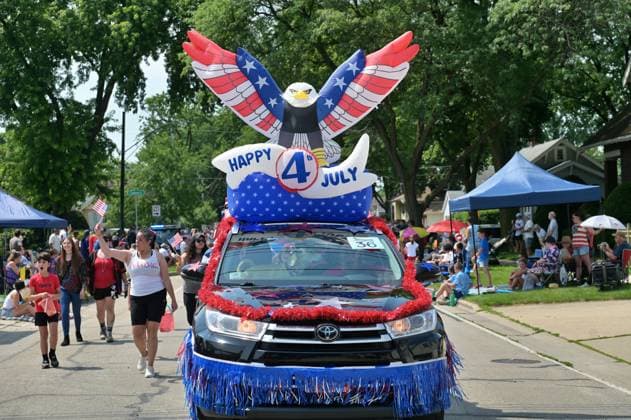 4th of July Parade in Des Plaines, Illinois DES PLAINES, ILLINOIS - JULY 04: A black Toyota SUV, decorated as a float, participates in the Des Plaines 4th of July Parade. The vehicle features a large inflatable patriotic eagle with spread wings displaying stars and stripes, a banner reading HAPPY 4th JULY, and is trimmed with red, white, and blue tinsel and fringe. Participants walk alongside waving small American flags, with spectators watching from the sidewalks on a sunny day in Illinois. Jacek Boczarski Anadolu Illinois United States. Editorial use only. Please get in touch for any other usage.  Copyright: x2026xAnadoluxJacekxBoczarskix