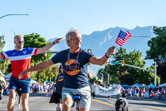 July 4, 2026, Provo, Utah, USA: A man waves a small American flag while riding a unicycle down the street alongside another unicyclist during America s Freedom Festival Grand Parade in Provo, Utah, Saturday, July 4, 2026. The annual Independence Day event features expanded programming to honor the 250th anniversary of United States independence. Provo USA  - ZUMAm292 20260704_znp_m292_135 Copyright: xCharlesxMcClintockxWilsonx