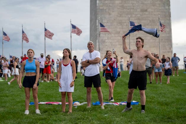 Attendees react to an announcement made to evacuate due to thunderstorms in the area during the Salute to America Independence Day celebration on the National Mall as watch the flyover on the National Mall in Washington, DC, on July 4, 2026. The nation is marking the 250th anniversary of the United States Declaration of Independence.  WAP20260704209 DANIELxHEUER