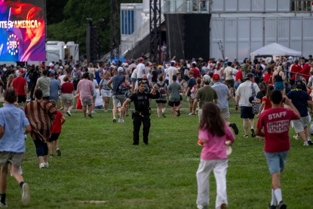 A US Secret Service officers shouts as attendees evacuate due to thunderstorms in the area during the Salute to America Independence Day celebration on the National Mall as watch the flyover on the National Mall in Washington, DC, on July 4, 2026. The nation is marking the 250th anniversary of the United States Declaration of Independence.  WAP20260704210 DANIELxHEUER