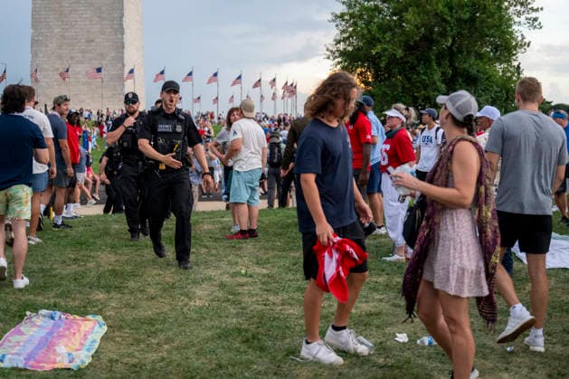 A US Secret Service officers shouts as attendees evacuate due to thunderstorms in the area during the Salute to America Independence Day celebration on the National Mall as watch the flyover on the National Mall in Washington, DC, on July 4, 2026. The nation is marking the 250th anniversary of the United States Declaration of Independence.  WAP202606240006 DANIELxHEUER