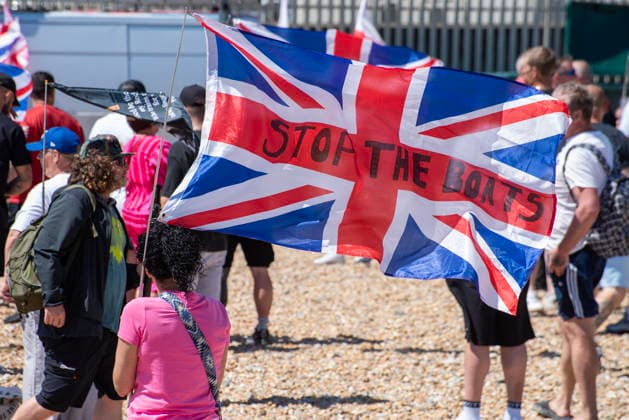 July 4, 2026, Dover, United Kingdom: A far-right activist holds a Union Jack flag during a demonstration outside the Immigration Centre in Dover. Around 100-120 supporters of the Pink Ladies gathered from across the country in Dover, UK. The Pink Ladies is an anti immigration far-right movement. The far-right activists marched through central Dover to the Immigration Centre and they were confronted by a small group of antifascist counter-protesters during their march. Dover United Kingdom - ZUMAs197 20260704_aaa_s197_220 Copyright: xKrisztianxElekx