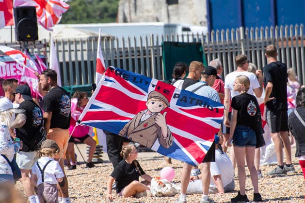 July 4, 2026, Dover, United Kingdom: A child holds a flag during a demonstration outside the Immigration Centre in Dover. Around 100-120 supporters of the Pink Ladies gathered from across the country in Dover, UK. The Pink Ladies is an anti immigration far-right movement. The far-right activists marched through central Dover to the Immigration Centre and they were confronted by a small group of antifascist counter-protesters during their march. Dover United Kingdom - ZUMAs197 20260704_aaa_s197_223 Copyright: xKrisztianxElekx
