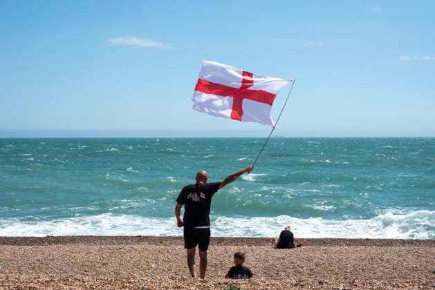 July 4, 2026, Dover, United Kingdom: A far-right protester waves a flag during a demonstration on the beach outside the Immigration Centre in Dover. Around 100-120 supporters of the Pink Ladies gathered from across the country in Dover, UK. The Pink Ladies is an anti immigration far-right movement. The far-right activists marched through central Dover to the Immigration Centre and they were confronted by a small group of antifascist counter-protesters during their march. Dover United Kingdom - ZUMAs197 20260704_aaa_s197_226 Copyright: xKrisztianxElekx
