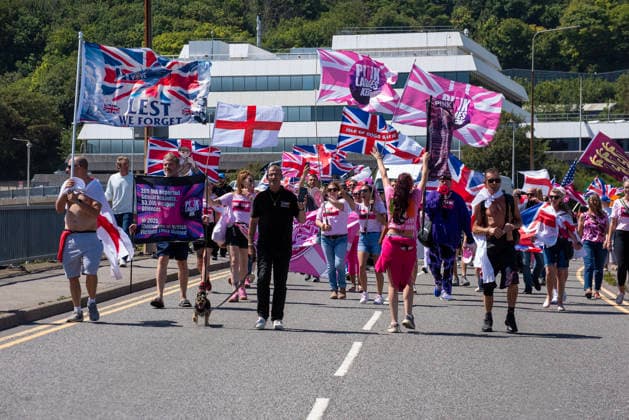 July 4, 2026, Dover, United Kingdom: Far-right protesters march with flags during a demonstration in Dover. Around 100-120 supporters of the Pink Ladies gathered from across the country in Dover, UK. The Pink Ladies is an anti immigration far-right movement. The far-right activists marched through central Dover to the Immigration Centre and they were confronted by a small group of antifascist counter-protesters during their march. Dover United Kingdom - ZUMAs197 20260704_aaa_s197_234 Copyright: xKrisztianxElekx