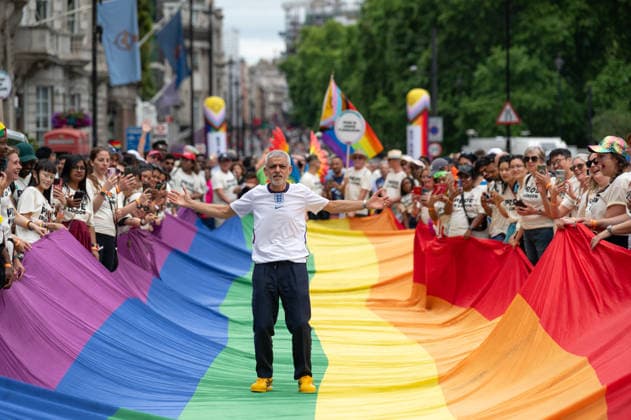July 4, 2026, London, United Kingdom: London Mayor Sadiq Khan stands on LGBTQ+ flag during the parade. Participants take part in the annual Pride in London parade through central London, celebrating LGBTQ+ communities and advocating for visibility, unity and equality. Thousands of marchers, community groups, charities, businesses and campaign organisations join the procession, which travels through the capital with colourful costumes, banners, music and performances. Participants take part in the annual Pride in London parade through central London, celebrating LGBTQ+ communities and advocating for visibility, unity and equality. Thousands of marchers, community groups, charities, businesses and campaign organisations join the procession, w  - ZUMAs197 20260704_aaa_s197_284 Copyright: xAndreaxDomeniconix