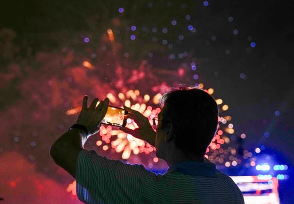 A spectator takes pictures as fireworks light up the night sky over the National Mall as part of the America 250 celebrations in Washington DC on Saturday, July 4, 2026. The 35 minute July 4 fireworks show will feature 850,000 fireworks and pyrotechnic effects.  WAP20260704919 BONNIExCASH
