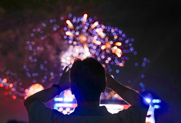 A spectator takes pictures as fireworks light up the night sky over the National Mall as part of the America 250 celebrations in Washington DC on Saturday, July 4, 2026. The 35 minute July 4 fireworks show will feature 850,000 fireworks and pyrotechnic effects.  WAP20260704921 BONNIExCASH
