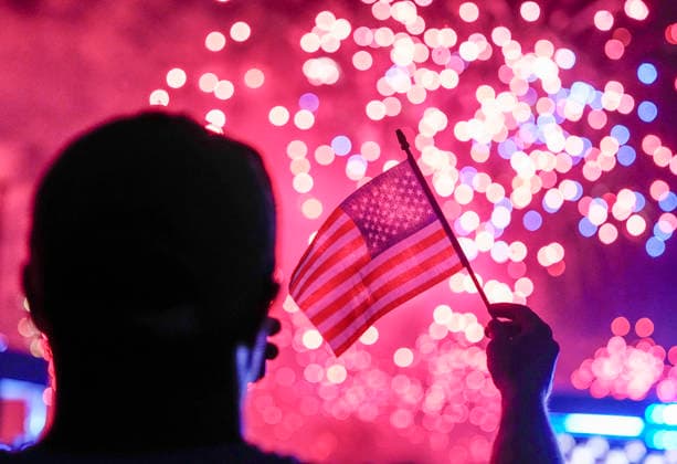 News Themen der Woche KW27 A spectator waves a flag as fireworks light up the night sky over the National Mall as part of the America 250 celebrations in Washington DC on Saturday, July 4, 2026. The 35 minute July 4 fireworks show will feature 850,000 fireworks and pyrotechnic effects.  WAP20260704924 BONNIExCASH