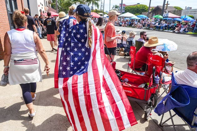 Coronado July 4th parade 2026, in California, USA - 04 Jul 2026 A woman walks on the streets with a flag of the United States during the parade. Spectators line Orange Avenue as participants march through the annual Independence Day Parade in Coronado on July 4, 2026. The parade, featuring marching bands, military units, community organizations, and decorated vehicles, was part of the city s Independence Day celebrations marking America s 250th birthday and drew thousands of residents and visitors to the coastal community of San Diego area. Coronado United States Copyright: xMichaelxHoxWaixLeex xSOPAxImagesx Michael Ho_5974