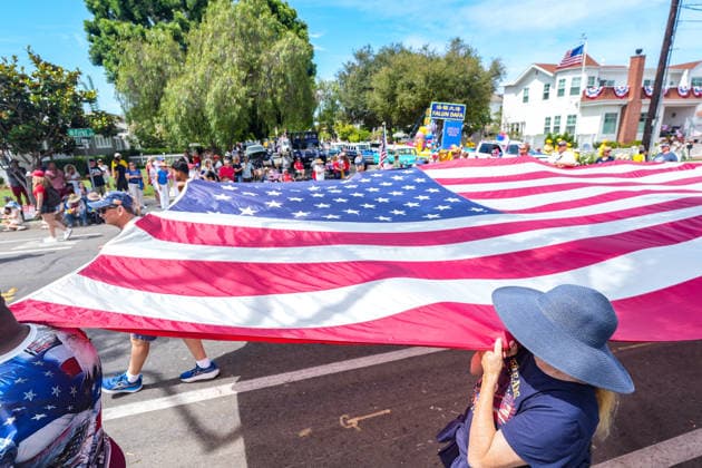 July 4, 2026, Coronado, California, United States: People hold a large America flag when they march on the streets. Spectators line Orange Avenue as participants march through the annual Independence Day Parade in Coronado on July 4, 2026. The parade, featuring marching bands, military units, community organizations, and decorated vehicles, was part of the city s Independence Day celebrations marking America s 250th birthday and drew thousands of residents and visitors to the coastal community of San Diego area. Coronado United States  - ZUMAs197 20260704_aaa_s197_346 Copyright: xMichaelxHoxWaixLeex
