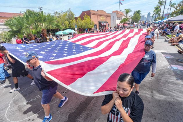 July 4, 2026, Coronado, California, United States: People hold a large America flag when they march on the streets. Spectators line Orange Avenue as participants march through the annual Independence Day Parade in Coronado on July 4, 2026. The parade, featuring marching bands, military units, community organizations, and decorated vehicles, was part of the city s Independence Day celebrations marking America s 250th birthday and drew thousands of residents and visitors to the coastal community of San Diego area. Coronado United States - ZUMAs197 20260704_aaa_s197_352 Copyright: xMichaelxHoxWaixLeex