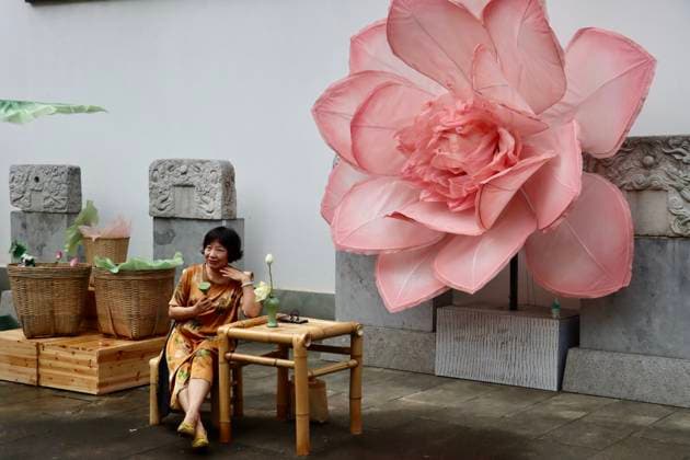 HANGZHOU, CHINA - JULY 04: A visitor poses for photo in front of a giant lotus art installation during a lotus market at the Confucius Temple on July 4, 2026 in Hangzhou, Zhejiang Province of China.  Copyright: xChinaxNewsxServicex 111652187604