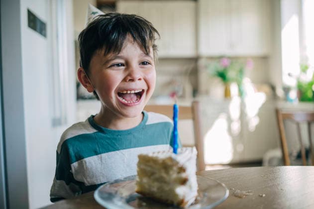 A laughing boy celebrates his birthday with a cake at home model released, Symbolfoto property released, ANAF06322
