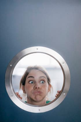 Portrait of woman pulling funny faces behind porthole model released, Symbolfoto property released, KNSF05456