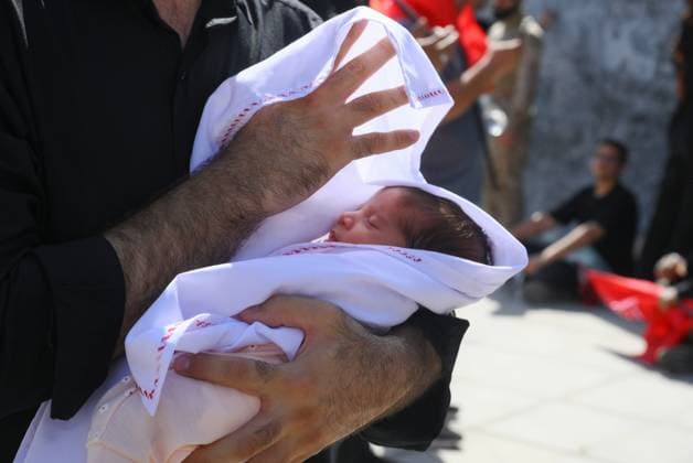 Iran Late Supreme Leader Funeral Rites 9200130 05.07.2026 A man holds a child as he attends a public farewell ceremony to pay respects to late Supreme Leader Ayatollah Ali Khamenei, who was killed on February 28 in Israeli and U.S. airstrikes, at the Imam Khomeini Grand Mosalla, in Tehran, Iran. Ilya Pitalev Sputnik Tehran Iran  Copyright: xIlyaxPitalevx