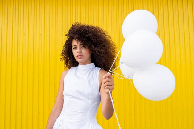 Woman in white dress holds white balloon on yellow background model released, Symbolfoto, LMCF03059