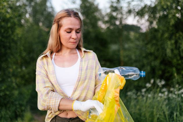 Woman collecting plastic waste outdoors for recycling model released, Symbolfoto, MKVF00259