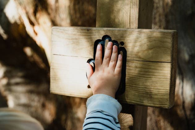 A girl touches a wooden palm sign on a hiking trail model released, Symbolfoto, NDEF03380