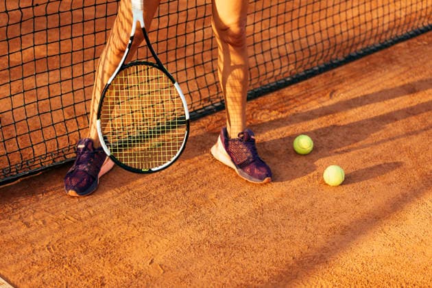 Female tennis player with racket and ball standing by sports court net during sunny day model released, Symbolfoto, OYF00509