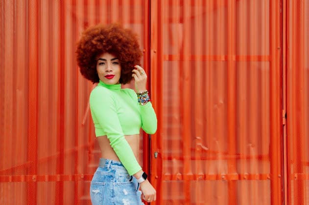Redhead woman wearing crop top in front standing by red wall model released, Symbolfoto, PGF00555