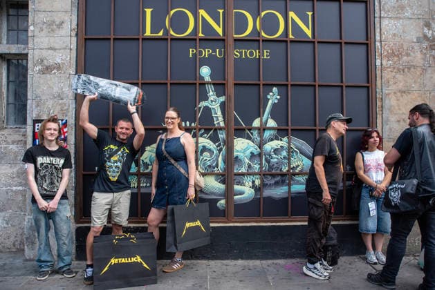 Metallica fans by the pop up ship in London, UK - 5Jul 2026 A family stand front of the Metallica banner outside the pop up shop in London. Metallica heavy metal band is having two concerts in London over the weekend as part of the M72 World Tour. Hundreds of Metallica fans were seen queuing up to buy some memorabilia by the Metallica pop up shop which is open for 4 days in London, UK. London United Kingdom Copyright: xKrisztianxElekx xSOPAxImagesx SSS_20260705_POPUP_SHOP_0011005014