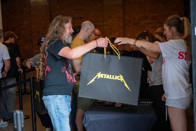 Metallica fans by the pop up ship in London, UK - 5Jul 2026 A staff hand over a Metallica shopping bag to the Metallica fan at the pop up shop in London. Metallica heavy metal band is having two concerts in London over the weekend as part of the M72 World Tour. Hundreds of Metallica fans were seen queuing up to buy some memorabilia by the Metallica pop up shop which is open for 4 days in London, UK. London United Kingdom Copyright: xKrisztianxElekx xSOPAxImagesx SSS_20260705_POPUP_SHOP_0011005025