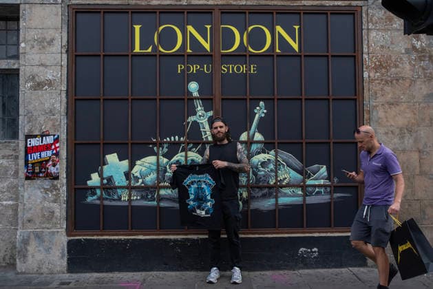 Metallica fans by the pop up ship in London, UK - 5Jul 2026 A fan pose with his t-shirt front of a Metallica poster outside the pop up shop in London. Metallica heavy metal band is having two concerts in London over the weekend as part of the M72 World Tour. Hundreds of Metallica fans were seen queuing up to buy some memorabilia by the Metallica pop up shop which is open for 4 days in London, UK. London United Kingdom Copyright: xKrisztianxElekx xSOPAxImagesx SSS_20260705_POPUP_SHOP_0011005034