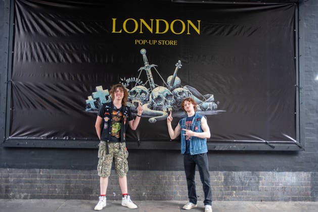 Metallica fans by the pop up ship in London, UK - 5Jul 2026 Two fans pose front of a Metallica banner nearby the pop up shop in London. Metallica heavy metal band is having two concerts in London over the weekend as part of the M72 World Tour. Hundreds of Metallica fans were seen queuing up to buy some memorabilia by the Metallica pop up shop which is open for 4 days in London, UK. London United Kingdom Copyright: xKrisztianxElekx xSOPAxImagesx SSS_20260705_POPUP_SHOP_0011005060