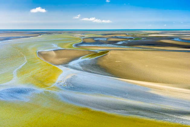 Creative Highlights World Aerial view captures a coastal mudflat at low tide in Normandy, STSF04102