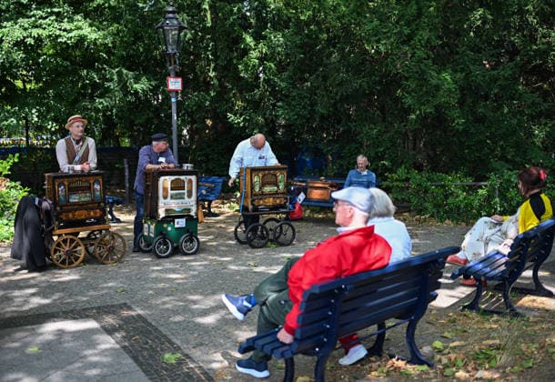 (260706) -- BERLIN, July 6, 2026 -- A barrel organ player (3rd L, rear) performs during the International Barrel Organ Festival 2026 in Berlin, Germany, July 5, 2026. The International Barrel Organ Festival 2026 was held in Berlin from July 3 to 5. Barrel organ players from across the world gathered here to entertain residents and visitors with a nostalgic musical celebration. ) GERMANY-BERLIN-BARREL ORGAN FESTIVAL ZhangxHaofu 