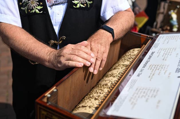 (260706) -- BERLIN, July 6, 2026 -- A player shows the interior structure of his barrel organ in Berlin, Germany, July 5, 2026. The International Barrel Organ Festival 2026 was held in Berlin from July 3 to 5. Barrel organ players from across the world gathered here to entertain residents and visitors with a nostalgic musical celebration. ) GERMANY-BERLIN-BARREL ORGAN FESTIVAL ZhangxHaofu 