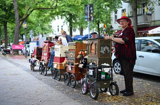 (260706) -- BERLIN, July 6, 2026 -- A barrel organ player (1st R) performs during the International Barrel Organ Festival 2026 in Berlin, Germany, July 5, 2026. The International Barrel Organ Festival 2026 was held in Berlin from July 3 to 5. Barrel organ players from across the world gathered here to entertain residents and visitors with a nostalgic musical celebration. ) GERMANY-BERLIN-BARREL ORGAN FESTIVAL ZhangxHaofu 