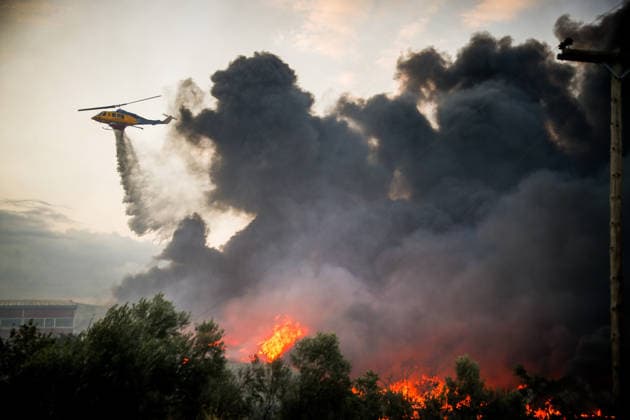 (260706) -- THESSALONIKI, July 6, 2026 -- Huge smoke rises from a wildfire on the outskirts of Thessaloniki, Greece, July 5, 2026. Greece s second-largest city, Thessaloniki, was blanketed by toxic smoke on Sunday after a wildfire set two factories ablaze on its outskirts, the Greek Fire Service said. (Photo by Xinhua) GREECE-THESSALONIKI-WILDFIRE VasilisxVerveridis 