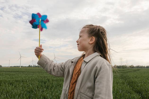 Girl holds a pinwheel in a field with wind turbines model released, Symbolfoto, VIVF01904