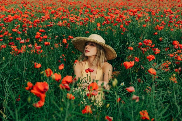 Woman in yellow dress and straw hat sits in a red poppy field model released, Symbolfoto, VSNF05071