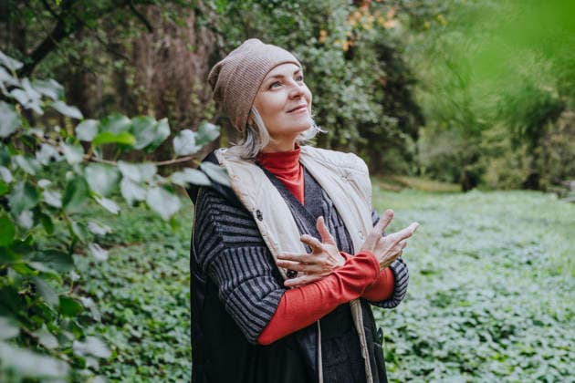Smiling woman wearing warm clothes standing in forest model released, Symbolfoto, YTF00244