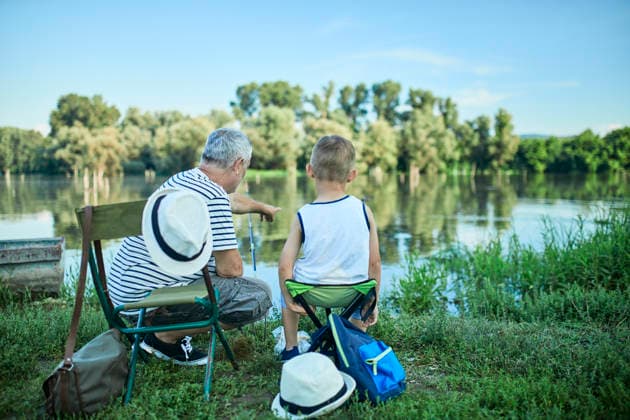 Back view of grandfather and grandson fishing together at lakeshore model released, Symbolfoto, ZEDF01478