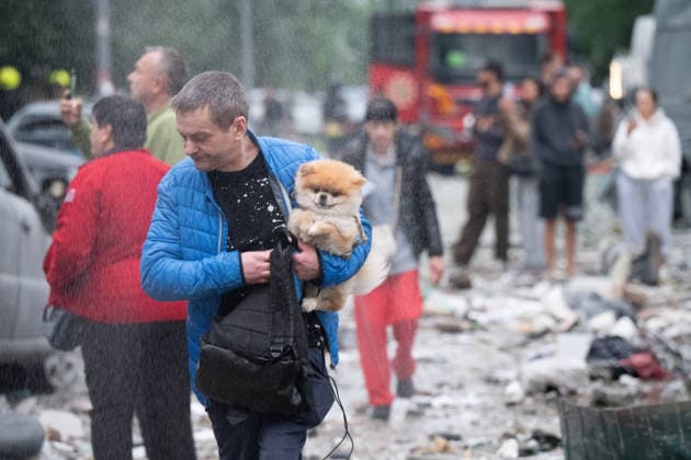 Russian attack on Kyiv leaves 10 dead KYIV, UKRAINE - JULY 06: A man holding a dog passes by a street in the residential area damaged during the Russian attack In Kyiv, Ukraine, on July 06, 2026. Stringer Anadolu Kyiv Ukraine. Editorial use only. Please get in touch for any other usage.  Copyright: x2026xAnadoluxStringerx